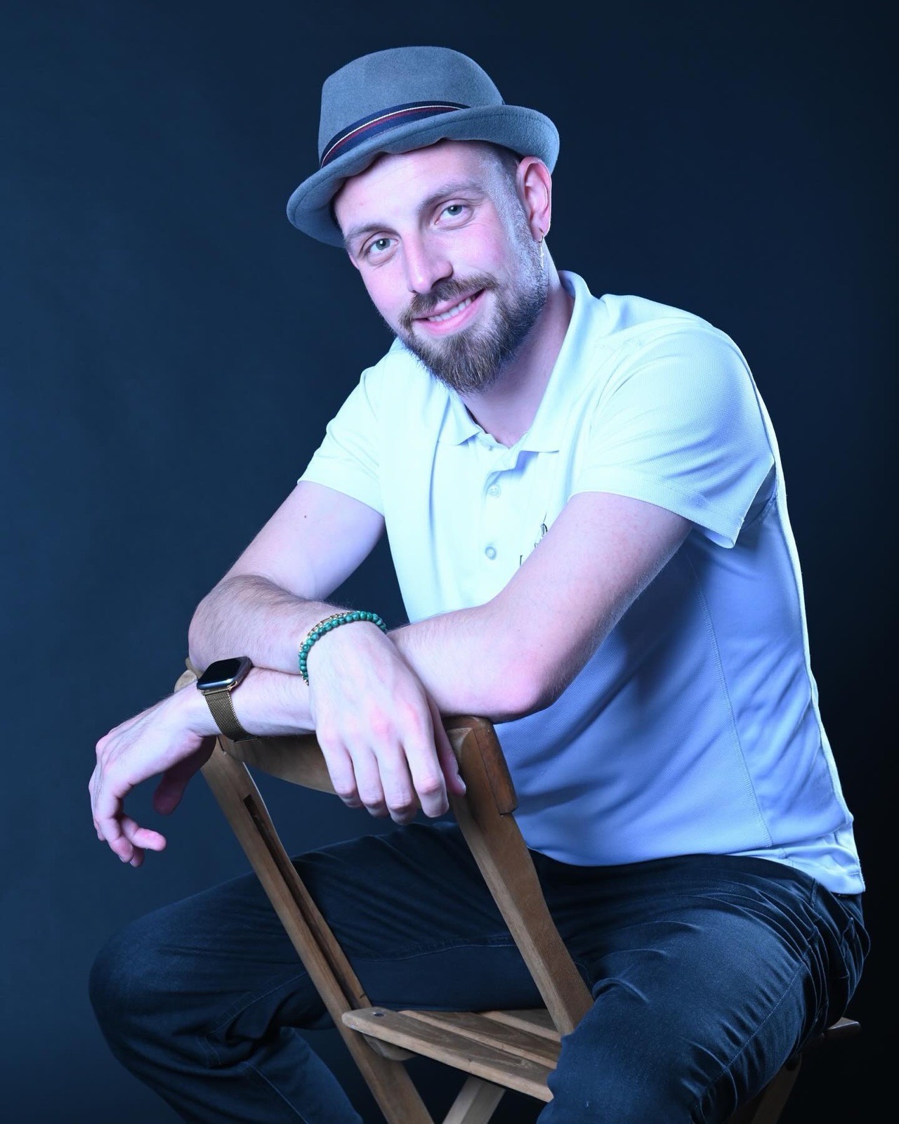 DJ Lio mit Hut, sitzend auf einem Holzstuhl
